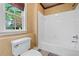 Bright bathroom featuring a tub and shower combination and a window view at 940 Magnolia Blossom Ct, Alpharetta, GA 30005