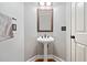 Pedestal sink in half bathroom featuring wood base trim and brushed bronze fixtures at 940 Magnolia Blossom Ct, Alpharetta, GA 30005