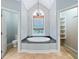 Bright bathroom boasts a large soaking tub under a picture window at 940 Magnolia Blossom Ct, Alpharetta, GA 30005