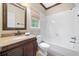 Bathroom with granite vanity, toilet, and tiled shower/tub with window at 940 Magnolia Blossom Ct, Alpharetta, GA 30005