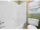 Well-lit bathroom featuring a tub with tile surround and modern fixtures at 940 Magnolia Blossom Ct, Alpharetta, GA 30005
