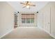 Bright bedroom with large windows, neutral carpet, ceiling fan, and adjacent room through glass paneled doors at 940 Magnolia Blossom Ct, Alpharetta, GA 30005