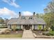 Community clubhouse featuring a well-manicured lawn, stone chimneys, and a welcoming entrance at 940 Magnolia Blossom Ct, Alpharetta, GA 30005