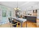 Dining area with chandelier open to kitchen and featuring a walkout to the deck at 940 Magnolia Blossom Ct, Alpharetta, GA 30005