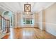 Elegant dining room featuring hardwood floors, modern lighting fixture, and a large arched window at 940 Magnolia Blossom Ct, Alpharetta, GA 30005