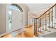 Welcoming foyer with hardwood floors, staircase with rod iron balusters, and views into the formal dining room at 940 Magnolia Blossom Ct, Alpharetta, GA 30005
