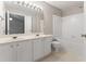 Bright bathroom featuring a double vanity, soaking tub with white tile surround and neutral flooring at 1730 Stanwood Nw Dr, Kennesaw, GA 30152