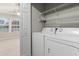 Convenient laundry area with appliances, shelving, and natural light from the window at 1730 Stanwood Nw Dr, Kennesaw, GA 30152
