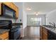 Kitchen view showing hardwood floors, granite countertops, black appliances, and a sunlit living area at 4333 Dunwoody Park # 1211, Atlanta, GA 30338