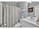 Bright bathroom features a modern vanity, white sink, and a shower with a decorative floral curtain at 735 Ambur Cove Way Nw, Lawrenceville, GA 30043