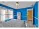 Blue bedroom with a window and carpet; storage shelves next to a doorway at 735 Ambur Cove Way Nw, Lawrenceville, GA 30043