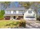 Charming two-story home featuring a manicured lawn, lush landscaping, and a welcoming front porch at 735 Ambur Cove Way Nw, Lawrenceville, GA 30043