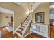 Bright foyer features hardwood floors, staircase with white risers, and a decorative bench at 735 Ambur Cove Way Nw, Lawrenceville, GA 30043
