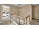 Bright hallway landing showcases a staircase with access to bedrooms, enhancing the home's layout at 735 Ambur Cove Way Nw, Lawrenceville, GA 30043