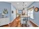Kitchen island with granite countertop seating area, hardwood floors and view to dining room at 735 Ambur Cove Way Nw, Lawrenceville, GA 30043