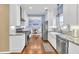 Bright kitchen features white cabinetry, stainless steel appliances, and hardwood flooring at 735 Ambur Cove Way Nw, Lawrenceville, GA 30043