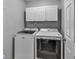 Functional laundry room featuring a modern washer and dryer, with neutral paint and storage space at 735 Ambur Cove Way Nw, Lawrenceville, GA 30043