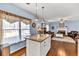 Open living room area with an island, hardwood floors and large window at 735 Ambur Cove Way Nw, Lawrenceville, GA 30043