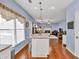 Open living room area with an island, hardwood floors and large window at 735 Ambur Cove Way Nw, Lawrenceville, GA 30043