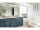 Modern bathroom with dual vanities, blue cabinets, and soaking tub at 103 New Hood Rd, Stockbridge, GA 30281