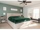 Comfortable bedroom with large bed, green accent wall, bench seating, and natural light at 103 New Hood Rd, Stockbridge, GA 30281