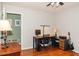 A well-lit office space with hardwood floors, desk, computer, and guitar at 103 New Hood Rd, Stockbridge, GA 30281