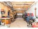 View of a large workshop with open ceiling, work tables, and various equipment leading to a garage door at 103 New Hood Rd, Stockbridge, GA 30281