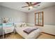 Bright bedroom featuring carpeted floors, ceiling fan, and wood-framed windows at 3141 Branford Ct, Marietta, GA 30062
