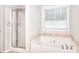 Bathroom featuring a glass shower, tub, and window at 3320 Gardenside Dr, Loganville, GA 30052