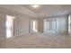 Spacious carpeted primary bedroom with tray ceiling and access to other rooms at 3320 Gardenside Dr, Loganville, GA 30052