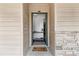 Charming front entrance featuring stone accent wall and key-shaped doormat with a view into the home's interior at 113 Brittany Ct, Duluth, GA 30096