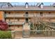 Three-story condo with wooden staircase, painted railings, and well-maintained landscaping at 113 Brittany Ct, Duluth, GA 30096
