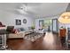 Inviting living room with hardwood floors, sectional sofa, and a fireplace, with natural light from glass doors at 113 Brittany Ct, Duluth, GA 30096