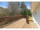 Back deck with natural wood finish, offering a serene outdoor space with views of lush greenery and trees at 209 Emma Gilley Dr, Carrollton, GA 30116