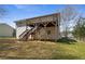 Spacious backyard with a wooden deck, stairs, and lush green grass, perfect for outdoor activities and entertaining at 209 Emma Gilley Dr, Carrollton, GA 30116