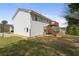 Backyard view features a spacious lawn, wooden deck with stairs, a basketball hoop, and a well-lit exterior door at 209 Emma Gilley Dr, Carrollton, GA 30116