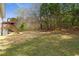 Expansive backyard featuring a well-maintained lawn, mature trees, and a wooden deck with stairs, ideal for outdoor living at 209 Emma Gilley Dr, Carrollton, GA 30116