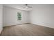 An empty bedroom is brightened by a large window and has modern hardwood floors at 209 Emma Gilley Dr, Carrollton, GA 30116