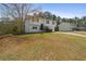 Split-level home with white siding, complemented by a spacious lawn and surrounding trees at 209 Emma Gilley Dr, Carrollton, GA 30116