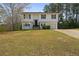Split-level home showcasing a classic white facade, dark shutters, and well-maintained front lawn at 209 Emma Gilley Dr, Carrollton, GA 30116