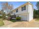 Split-level home with attached garage, set against a backdrop of lush greenery at 209 Emma Gilley Dr, Carrollton, GA 30116