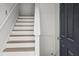 Interior staircase with white risers and natural wood treads, complemented by a modern door at 209 Emma Gilley Dr, Carrollton, GA 30116