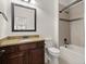 Elegant bathroom featuring a granite vanity, framed mirror, and bathtub with tiled surround at 5925 Pine Bluff Dr, Cumming, GA 30040