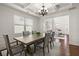 Formal dining room with a coffered ceiling, elegant lighting, and open to the living area at 5925 Pine Bluff Dr, Cumming, GA 30040