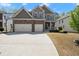 Beautiful two-story home with a stone and gray exterior, two-car garage, and well-manicured lawn at 5925 Pine Bluff Dr, Cumming, GA 30040