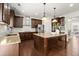 Modern kitchen with dark wood cabinets, granite countertops, stainless steel appliances, and a kitchen island at 5925 Pine Bluff Dr, Cumming, GA 30040