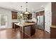Spacious kitchen featuring dark wood cabinets, granite countertops, a central island, and stainless steel appliances at 5925 Pine Bluff Dr, Cumming, GA 30040