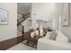 Open-concept living room with hardwood floors, high ceilings, staircase, and view into the dining room at 5925 Pine Bluff Dr, Cumming, GA 30040