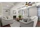 Cozy living room with a fireplace, built-in shelving, and large windows at 5925 Pine Bluff Dr, Cumming, GA 30040
