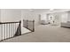 Spacious loft area with neutral carpet, white walls, and staircase with dark-stained banister at 5925 Pine Bluff Dr, Cumming, GA 30040